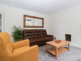 A living room with sofa, armchair, coffee table and mirror at Flat 2 Battledown Grange Cheltenham