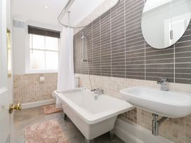 A bathroom with a bathtub, washbasin and mirror at Flat 2 Battledown Grange, Cheltenham