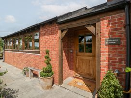 An entrance with a wooden door and plants at Little Acorn Cottage Munsley near Ledbury