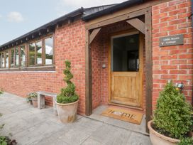 An outdoor entrance with a wooden door and welcome mat at Little Acorn Cottage in Munsley near Ledbury