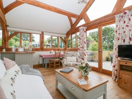 A living room with a sofa and dining table at Little Acorn Cottage in Munsley near Ledbury