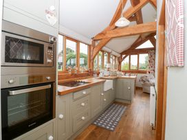 A kitchen with appliances and a window view at Little Acorn Cottage in Munsley near Ledbury
