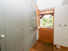 A hallway with wardrobe and door leading outside at Little Acorn Cottage in Munsley near Ledbury