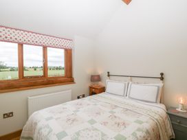 A bedroom with a bed and bedside table at Little Acorn Cottage in Munsley near Ledbury