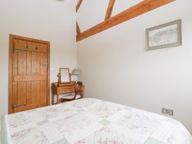 A bedroom with a bed and a table at Little Acorn Cottage in Munsley near Ledbury