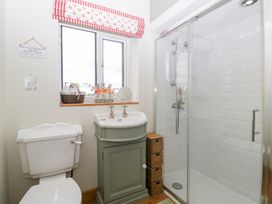 A bathroom with a shower, sink, and toilet at Little Acorn Cottage in Munsley near Ledbury