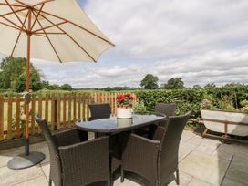 An outdoor seating area with a table and chairs at Little Acorn Cottage in Munsley near Ledbury