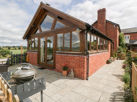 A conservatory with large windows and a barbecue at Little Acorn Cottage Munsley near Ledbury