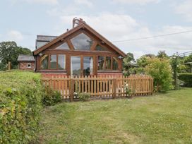 A cottage with a wooden fence and garden at Little Acorn Cottage in Munsley near Ledbury