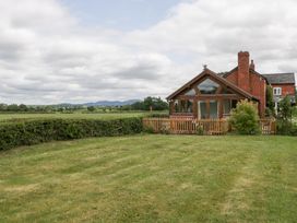A house with a garden and fence at Little Acorn Cottage in Munsley near Ledbury