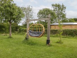 A hanging chair in a garden at Little Acorn Cottage in Munsley near Ledbury