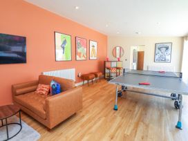 A game room with a ping pong table and a sofa at Ardwyn Rhosneigr