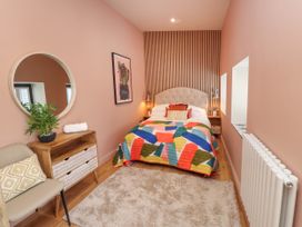 A bedroom with a bed and colorful quilt at Ardwyn in Rhosneigr