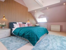 A bedroom with a bed and decorative furniture at Ardwyn Rhosneigr