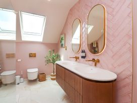 A bathroom with a washbasin and mirrors at Ardwyn in Rhosneigr