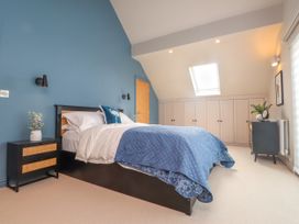 A bedroom with a bed and nightstand at Ardwyn Rhosneigr