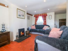 A living room with sofas and a fireplace at Brynffynon in Pwllheli