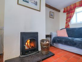A living room with a fireplace and a sofa at Brynffynon in Pwllheli