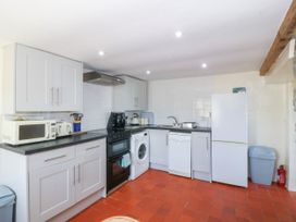 A kitchen with cabinets, microwave, stove, and refrigerator at Brynffynon in Pwllheli