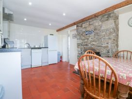 A kitchen with a table and chairs at Brynffynon in Pwllheli