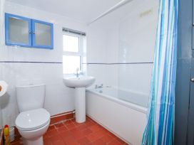 A bathroom with a toilet, sink, and bathtub at Brynffynon in Pwllheli