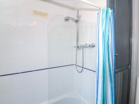 A shower with a curtain in a bathroom at Brynffynon Pwllheli