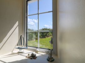 A window with a sailboat and stones at Brynffynon Pwllheli