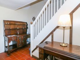 A hallway with a staircase and wooden furniture at Brynffynon in Pwllheli