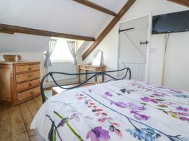 A bedroom with a bed and dresser at Brynffynon in Pwllheli