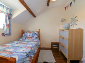 A bedroom with a bed and dresser at Brynffynon in Pwllheli
