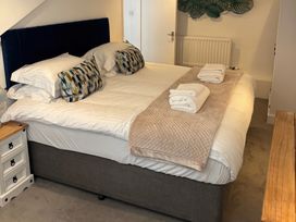 A bedroom with a double bed with white sheets and folded towels on a beige blanket at Moss Crag in Glenridding