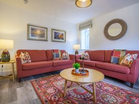 A living room with a sofa, coffee table, and lamp at Moss Crag in Glenridding