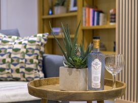 A living room with a plant and gin bottle on a wooden tray at Moss Crag in Glenridding
