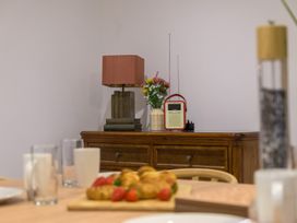 A dining room with a lamp and radio on a cabinet at Moss Crag in Glenridding