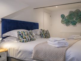 A bedroom with a double bed and decorative pillows at Moss Crag in Glenridding