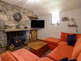 A living room with a stone fireplace Couch and a television at Fishermans Cottage in Prestatyn