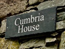 A sign for Cumbria House on a stone wall at Cumbria house