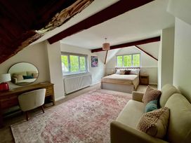 A bedroom with a bed, sofa, desk and windows at Cumbria house 