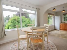 A dining area with a table and chairs and a refrigerator at Cumbria house