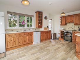 A kitchen with wooden cabinets and appliances at Cumbria house 