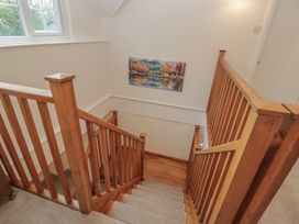 A staircase with wooden railing and a painting at Cumbria house