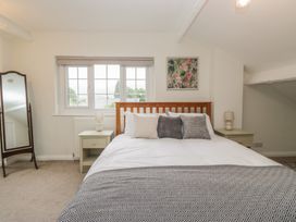 A bedroom with a bed, nightstands and a mirror at Cumbria house
