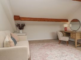 A snug with a sofa, desk, chair, and mirror at Cumbria house