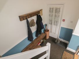 A hallway with coat rack, bench, and shoes at Cumbria house