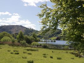 A landscape view of a lake surrounded by trees and hills at Cumbria house