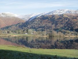 A view of mountains and a lake with reflections at Cumbria house