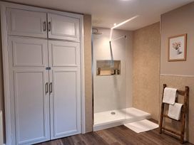 A bathroom with a shower and towels on a rack at Cumbria house in Grasmere