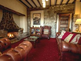 A living room with a fireplace and chess set at Noddfa Country House Harlech