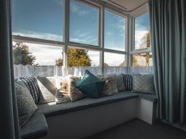 A snug with a sofa and cushions at Noddfa Country House in Harlech