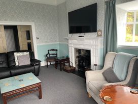 A living room with a television and fireplace at Noddfa Country House in Harlech